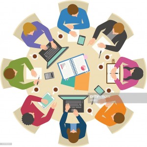 Office workers working hard at round table from directly above